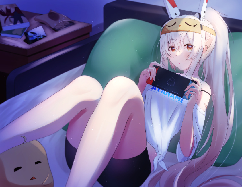 ayanami_(azur_lane) ayanami_(off-duty_battle_station_gear)_(azur_lane) azur_lane bed black_shorts character_name clothes_writing female hair_between_eyes headgear highres long_hair lying manjuu_(azur_lane) nintendo_switch off_shoulder on_back on_bed orange_eyes pillow ponytail shorts sleep_mask solo tako-san_wiener_(takosanuma) white_hair