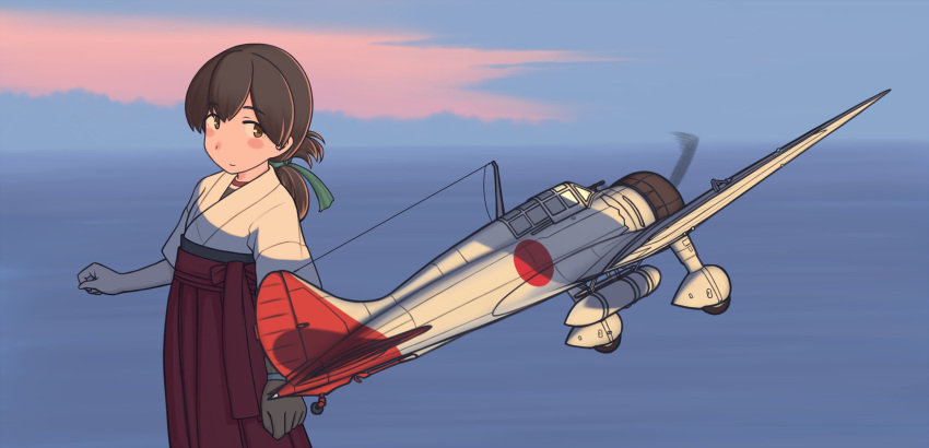 a5m aircraft airplane blush brown_eyes brown_hair commentary_request female folded_ponytail hair_ribbon hakama hakama_short_skirt hakama_skirt highres japanese_clothes kantai_collection kasuga_maru_(kancolle) long_hair ocean porusasu ribbon short_sleeves skirt solo sunset vehicle_focus