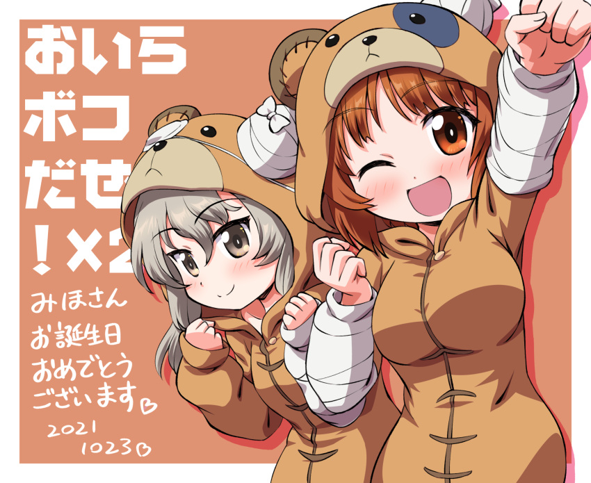 2girls ;d animal_costume bear_costume birthday boko_(girls_und_panzer) border brown_background brown_eyes brown_hair clenched_hands closed_mouth commentary dated girls_und_panzer happy_birthday highres inoue_kouji light_blush light_brown_hair long_hair looking_at_viewer multiple_girls nishizumi_miho one_eye_closed outside_border raised_fist shimada_arisu short_hair smile standing translated white_border