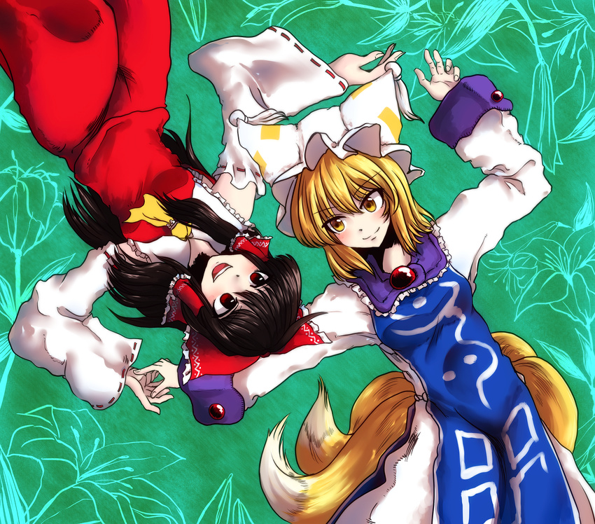 2girls animal_hat ascot bad_id bad_pixiv_id blonde_hair bow brown_eyes brown_hair detached_sleeves fox_tail hair_tubes hairbow hakurei_reimu hat highres long_hair long_sleeves lying mob_cap multiple_girls multiple_tails on_back open_mouth short_hair smile tabard tail tassel toluda touhou wide_sleeves yakumo_ran yellow_eyes