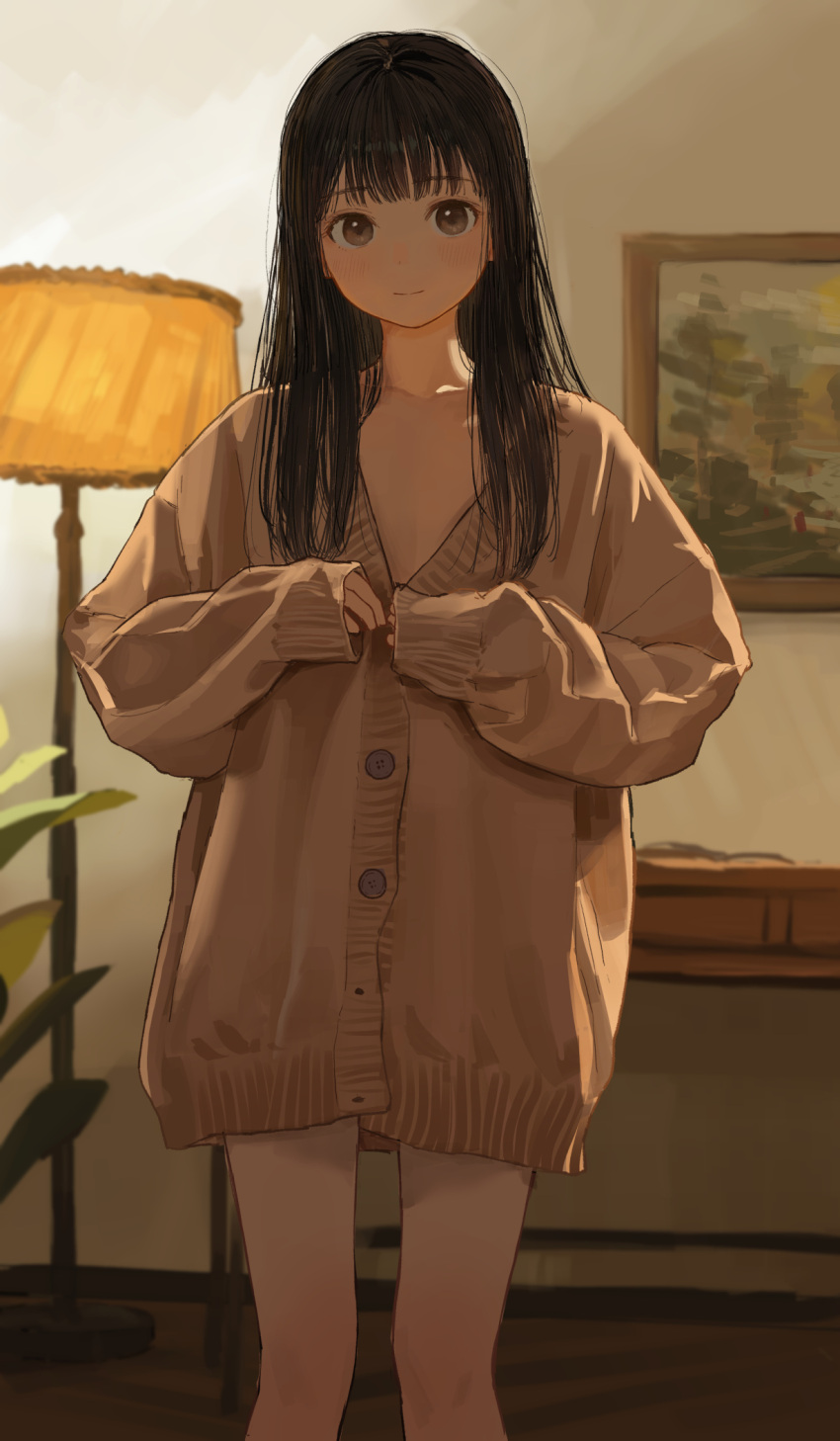 akipeko black_hair brown_cardigan brown_eyes cardigan closed_mouth commentary_request female floor_lamp highres indoors lamp light_smile long_hair looking_at_viewer no_pants original oversized_clothes portrait_(object) sleeves_past_wrists smile solo straight-on sweater tareme