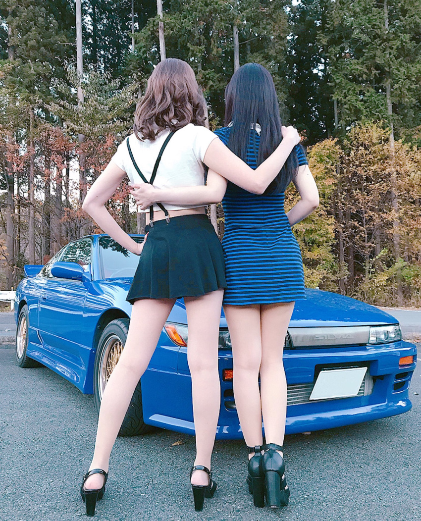 2girls arm_around_waist black_footwear black_hair black_skirt blue_car blue_dress brown_hair car collared_dress cosplay_photo dress from_behind hand_on_own_hip high_heels highres initial_d mayamelo5 motor_vehicle multiple_girls nissan nissan_180sx nissan_sileighty nissan_silvia nissan_silvia_s13 photo_(medium) satou_mako sayuki_(initial_d) shirt skirt sports_car suspenders white_shirt yuki_(bigbong)