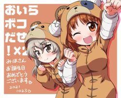  2girls ;d animal_costume bear_costume birthday boko_(girls_und_panzer) border brown_background brown_eyes brown_hair clenched_hands closed_mouth commentary dated girls_und_panzer happy_birthday highres inoue_kouji light_blush light_brown_hair long_hair looking_at_viewer multiple_girls nishizumi_miho one_eye_closed outside_border raised_fist shimada_arisu short_hair smile standing translated white_border 