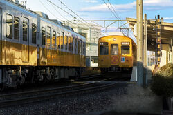  building cable cloud commentary_request day hankachi_(okayama012) highres no_humans original outdoors railroad_tracks reflection scenery shade sky speaker sunlight train train_station train_station_platform 