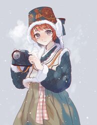  alternate_costume black_eyes black_headwear brown_skirt camera danganronpa_(series) danganronpa_2:_goodbye_despair female floral_print freckles fur_trim grey_background gwanlamcha highres holding holding_camera koizumi_mahiru korean_commentary long_sleeves looking_at_viewer red_hair short_hair skirt smile snowing solo 