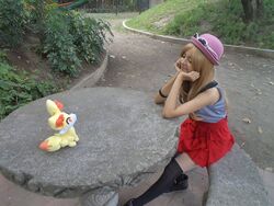  blonde_hair cosplay fennekin hat leggings pantyhose photo plush pokemon serena_(pokemon) shirt skirt sleeveless_shirt smile stuffed_toy sunglasses table 