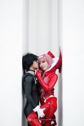  1boy bangs black_bodysuit black_hair blue_eyes bodysuit cosplay couple darling_in_the_franxx female gloves green_eyes hair_ornament hairband hiro_(darling_in_the_franxx) hiro_(darling_in_the_franxx)_(cosplay) horns long_hair oni_horns pilot_suit pink_hair red_bodysuit red_gloves red_horns straight white_gloves white_hairband zero_two_(darling_in_the_franxx) zero_two_(darling_in_the_franxx)_(cosplay) 