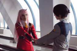  1boy bangs black_hair cosplay couple darling_in_the_franxx female green_eyes hair_ornament hairband hiro_(darling_in_the_franxx) hiro_(darling_in_the_franxx)_(cosplay) horns long_hair long_sleeves military military_uniform necktie oni_horns orange_neckwear pink_hair red_horns straight uniform white_hairband zero_two_(darling_in_the_franxx) zero_two_(darling_in_the_franxx)_(cosplay) 