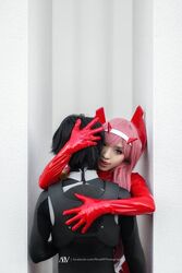  1boy bangs black_bodysuit black_hair bodysuit cosplay couple darling_in_the_franxx female gloves green_eyes hair_ornament hairband hiro_(darling_in_the_franxx) hiro_(darling_in_the_franxx)_(cosplay) horns long_hair oni_horns pilot_suit pink_hair red_bodysuit red_gloves red_horns straight white_hairband zero_two_(darling_in_the_franxx) zero_two_(darling_in_the_franxx)_(cosplay) 