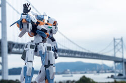  baselard_(frame_arms) blurry blurry_background bridge clenched_hand frame_arms green_eyes looking_at_viewer mecha model_kit model_kit_(medium) no_humans open_hand photo_(medium) robot solo suzu_(garage516) unconventional_media waving 