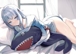  bare_legs barefoot bed_sheet blue_eyes blue_hair blue_hoodie blunt_bangs closed_mouth collarbone commentary female fins fish_tail gawr_gura gawr_gura_(1st_costume) grey_hair hair_ornament highres hololive hololive_english hood hoodie hugging_doll hugging_object indoors long_hair long_sleeves looking_at_viewer lying multicolored_hair on_bed on_side open_mouth shark_tail smile solo streaked_hair stuffed_animal stuffed_toy tail two_side_up virtual_youtuber yuuyuu_(yuuki1771) 