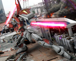  building city commentary_request crane_(machine) dual_wielding energy_sword fire glowing glowing_eyes green_eyes gundam gundam_seed gundam_seed_destiny hiropon_(tasogare_no_puu) holding impulse_gundam mecha no_humans photo_background robot shield smoke solo sword sword_impulse_gundam traffic_cone weapon 